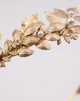 Extreme close-up of CARPO bridal headband showing the detailed veins of gold brass oak leaves and hand-wrapped ivory  pearls on a slim gold wire base.