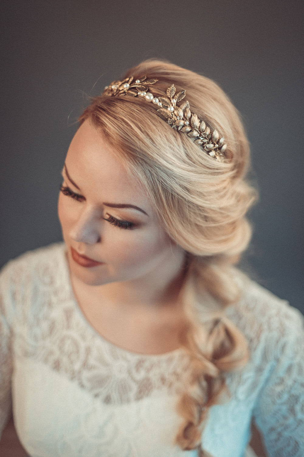 Carpo gold oak leaf bridal headband with  pearls shown on a bride with a textured blonde side braid.