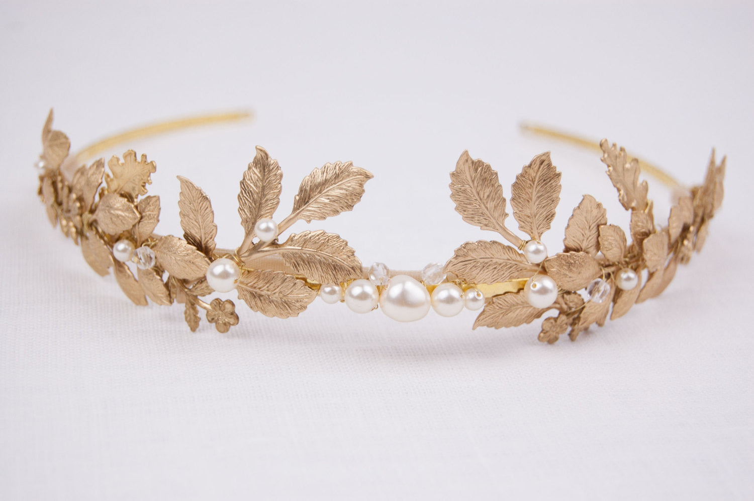 CARPO bridal headband showing the detailed veins of gold brass oak leaves and hand-wrapped ivory  pearls on a slim gold wire base.