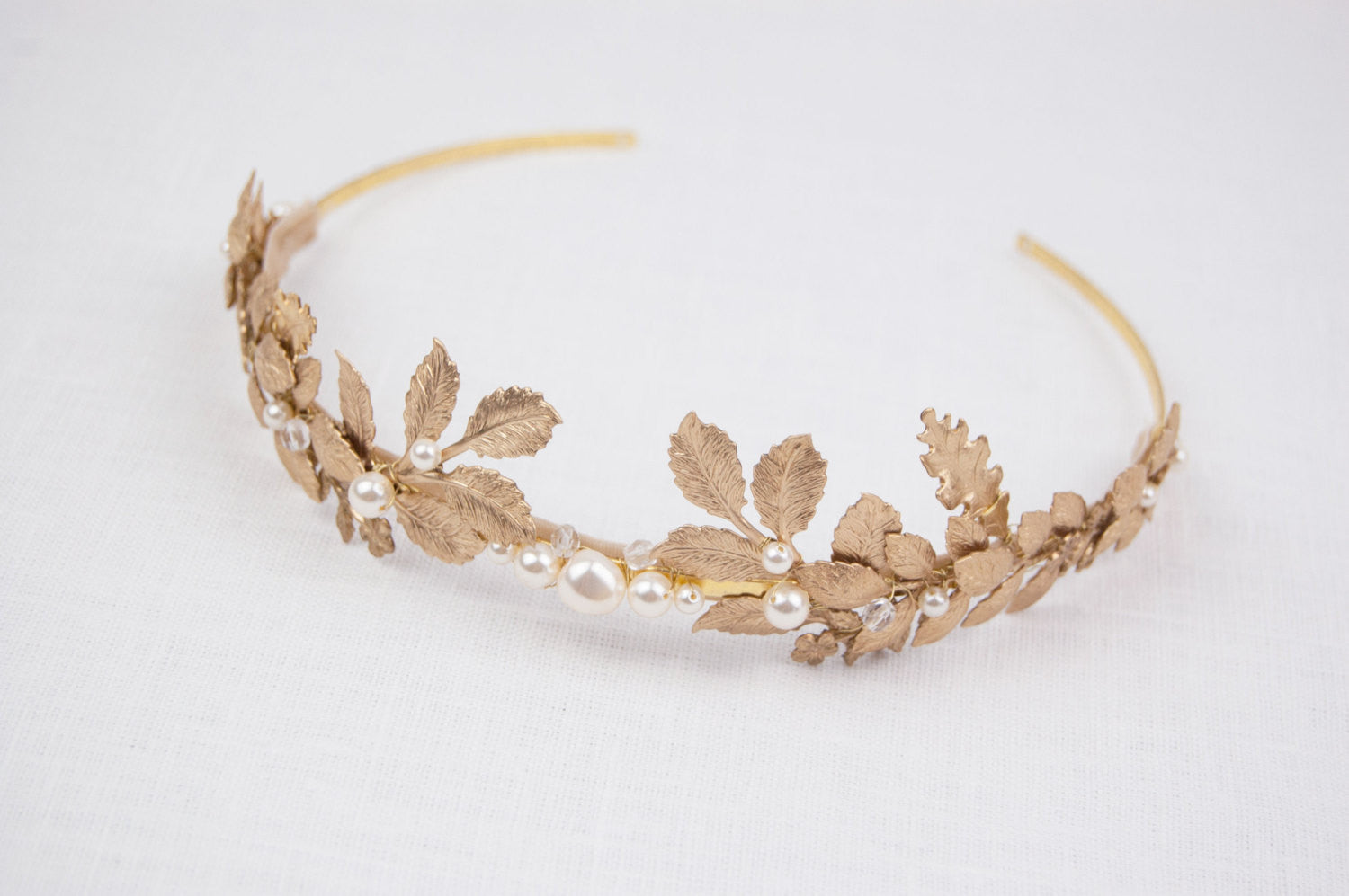 CARPO bridal headband showing the detailed veins of gold brass oak leaves and hand-wrapped ivory  pearls on a slim gold wire base.