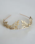 Close up of gold laurel leaves on bridal headband, matte brass leaf crown detail