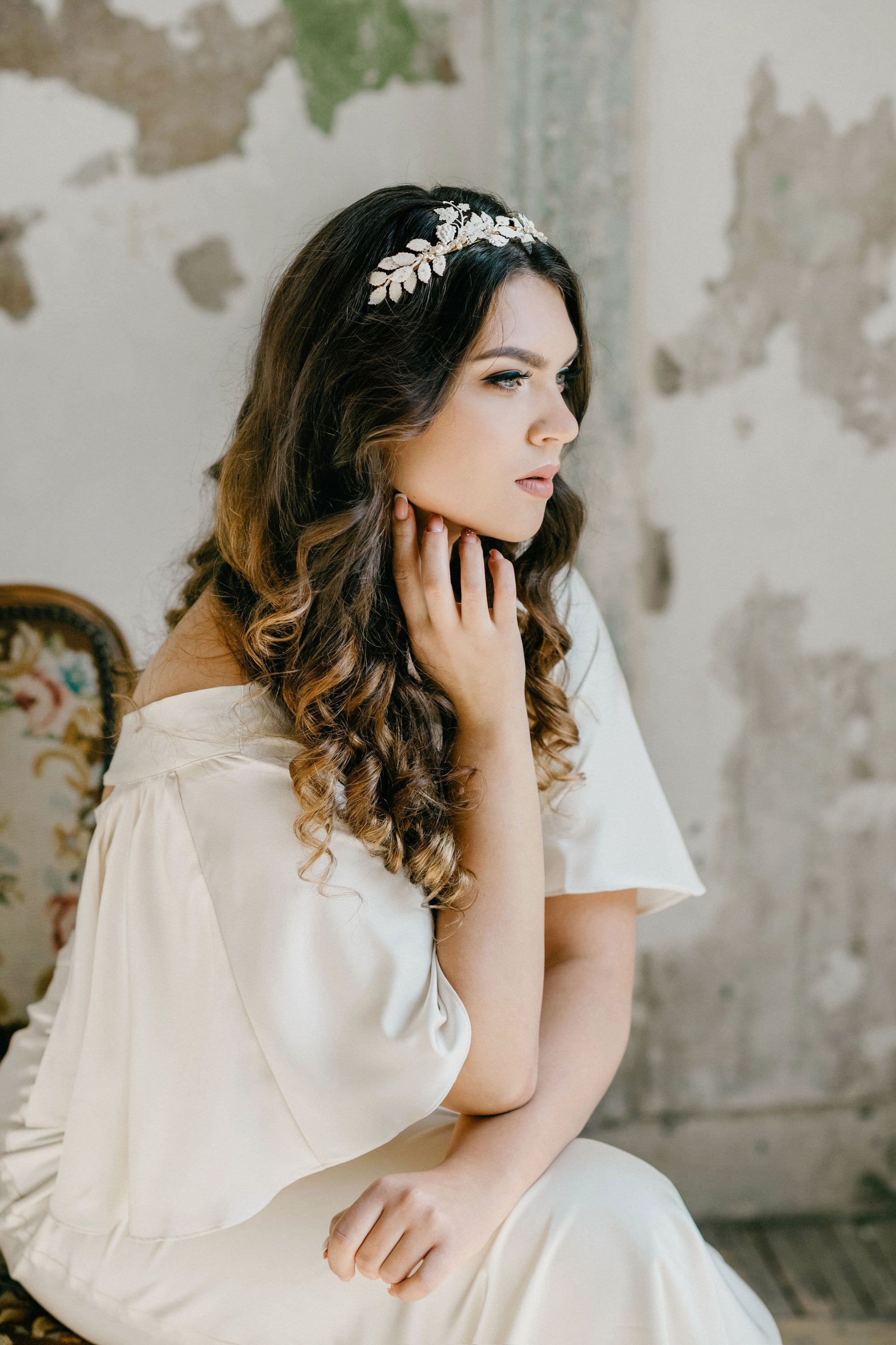 Victoria white leaf bridal tiara in hand-painted brass with pearls, shown on a bride in a minimalist editorial setting.