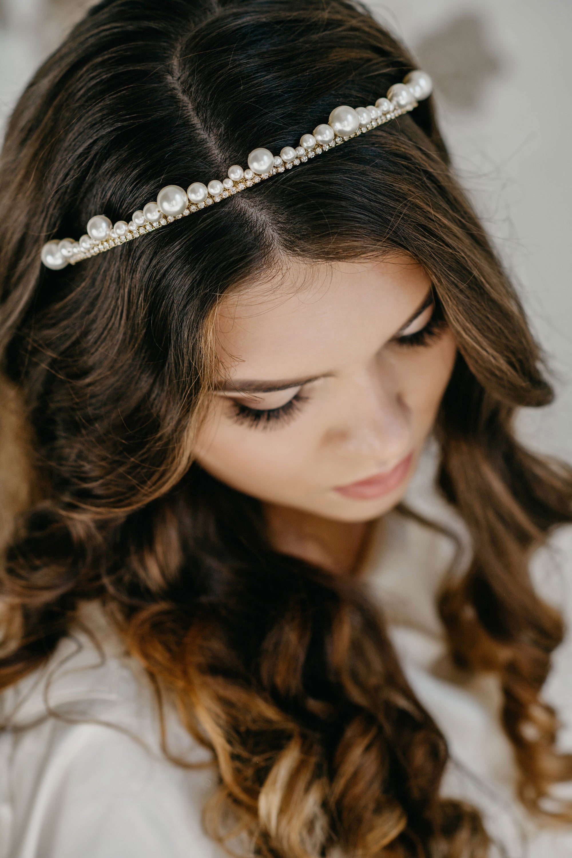 Model wearing ERDME pearl and crystal tiara in ivory cream with gold headband