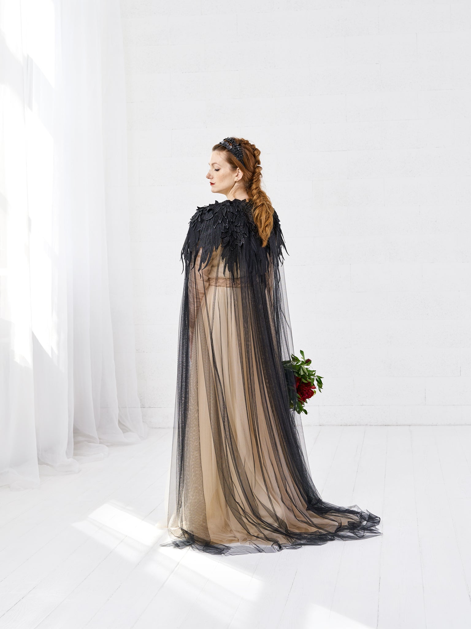 Bride wearing RAVEN black wedding cloak with feather lace and black rhinestones