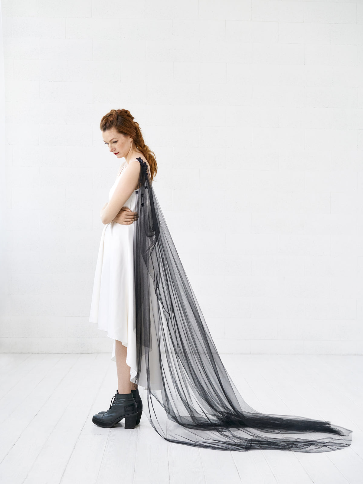 Bride wearing SABINE black floral cape veil draped across the back