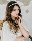 Lightweight pearl bridal tiara with scalloped pearl rows and crystal detailing on a minimalist bridal hairstyle