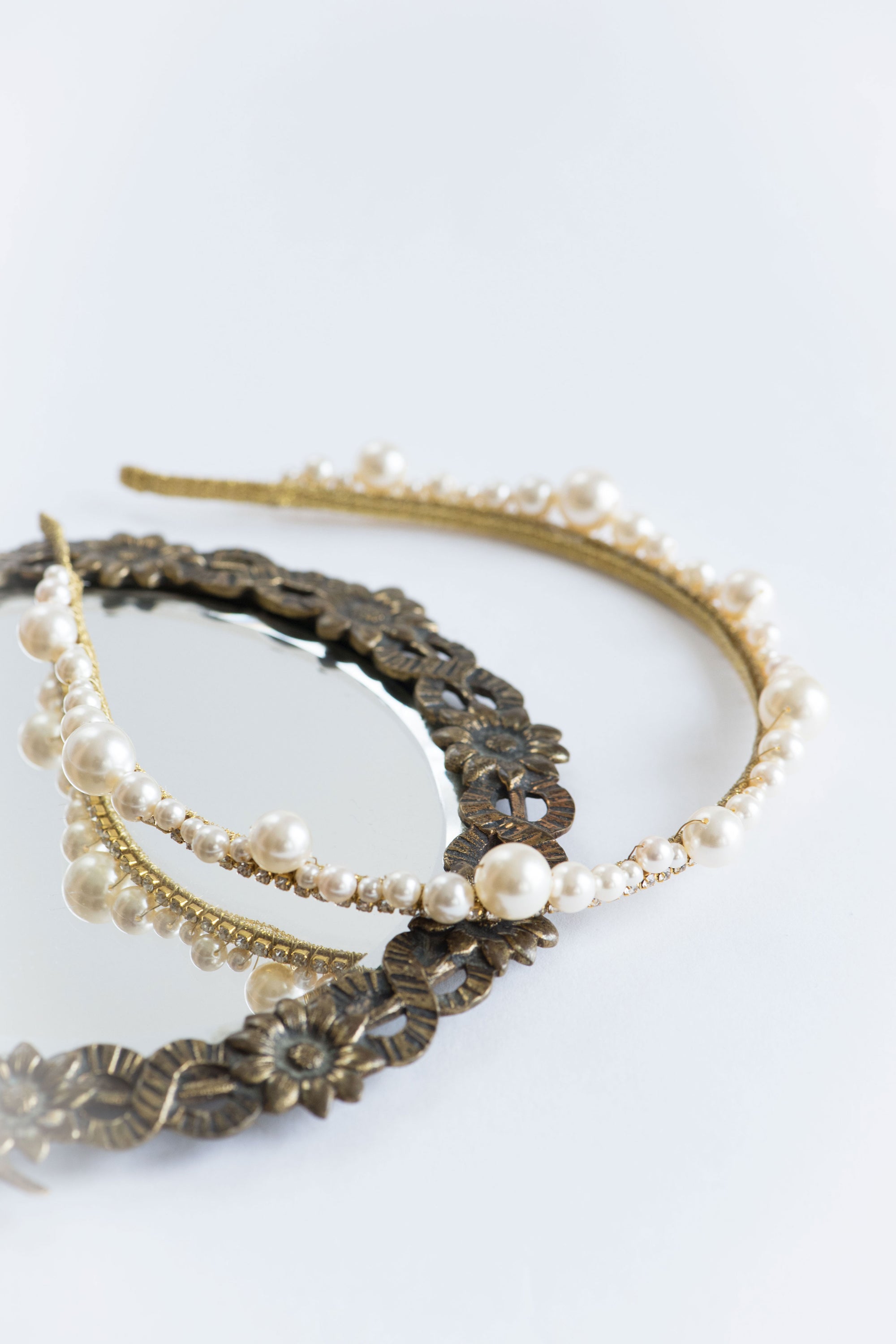 Handmade pearl bridal tiara with crystal accents on neutral background studio flat lay